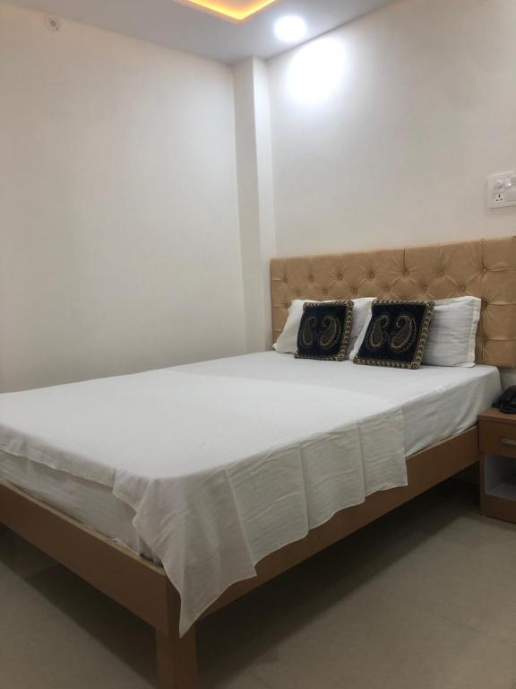 a bedroom with a large bed with two pillows on it at Purple Lotus Hotel in Varanasi