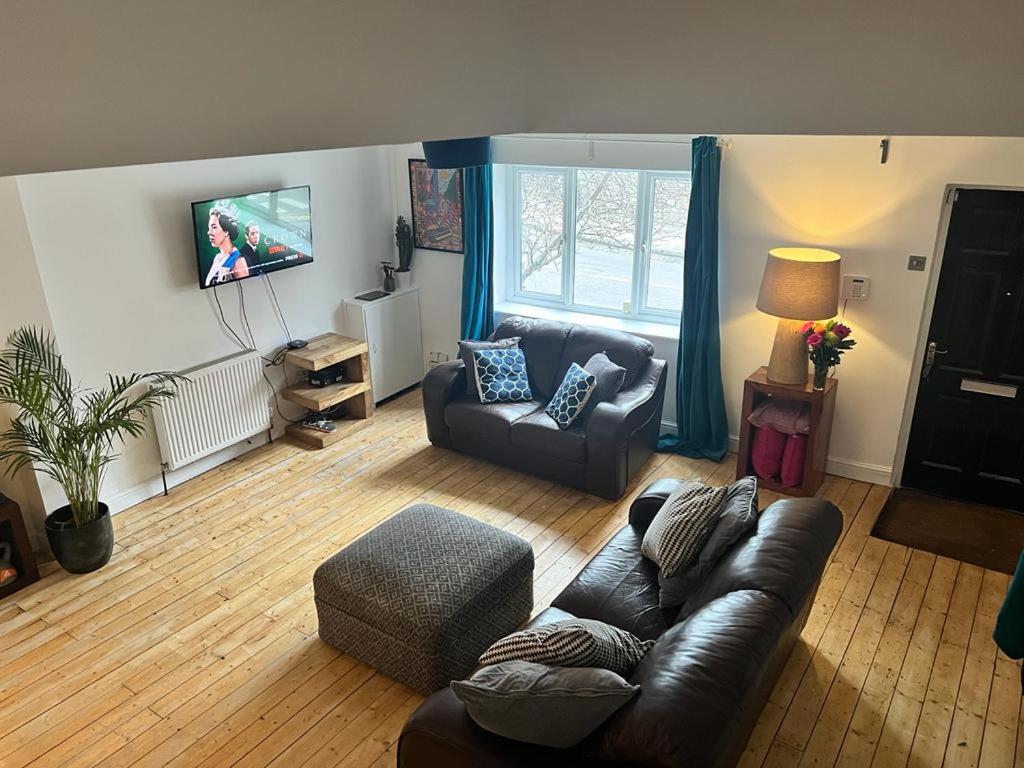 a living room with a couch and a tv at Spacious 3 bedroom house close to city centre in Bristol