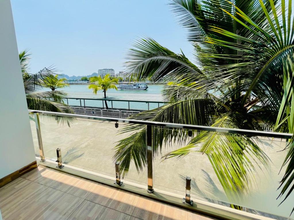 einen Balkon mit Blick auf den Strand und die Palmen in der Unterkunft Tuan Chau Havana Hotel in Hạ Long