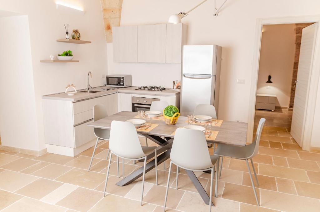 a kitchen with a wooden table and white cabinets at [ApuliaLux] Marietta Luxury House - Centro Storico in Brindisi