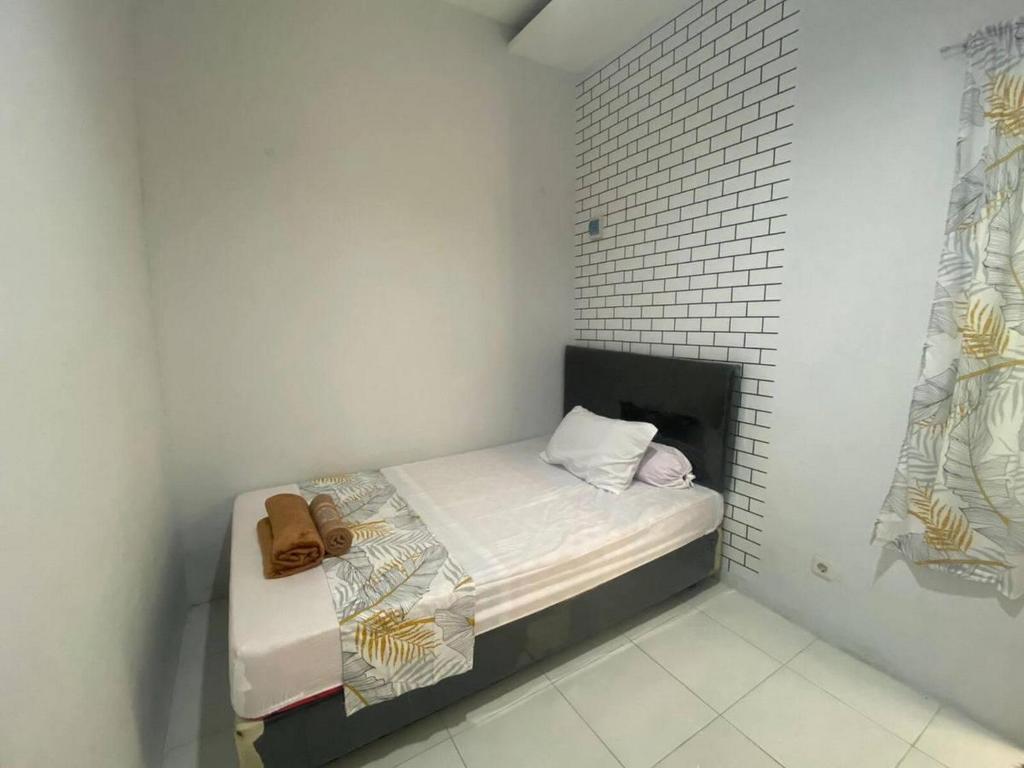 a small white room with a small bed in it at Pekayon Garden House Syariah RedPartner in Pekayon Dua