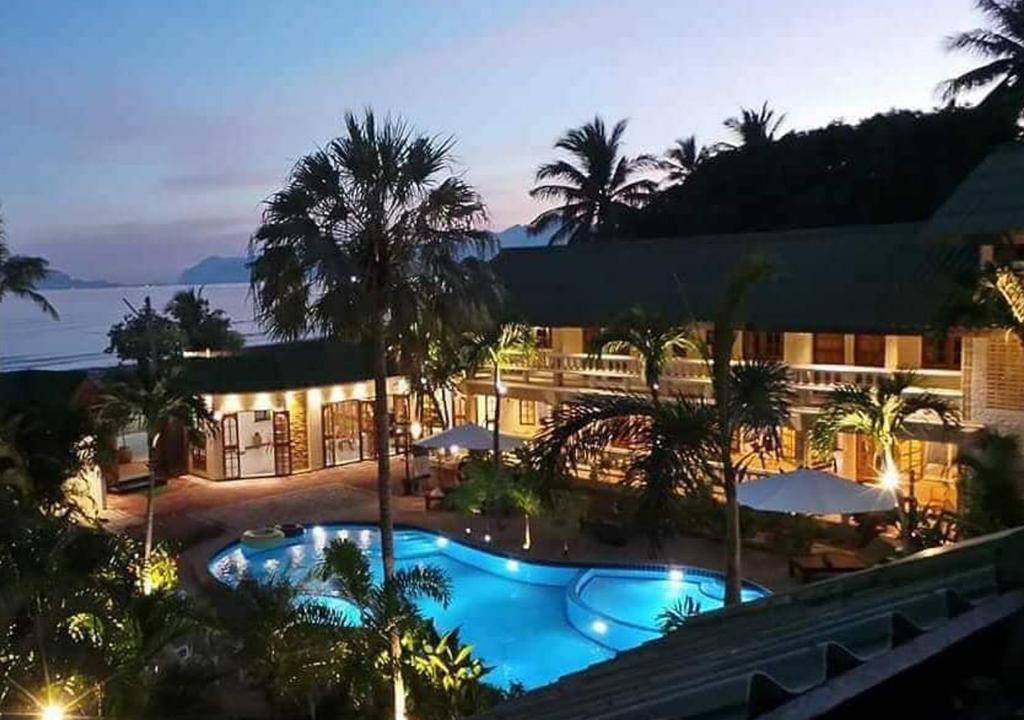 a hotel with a swimming pool at night at The Beach Boutique Resort in Ban Pak Nam Pran