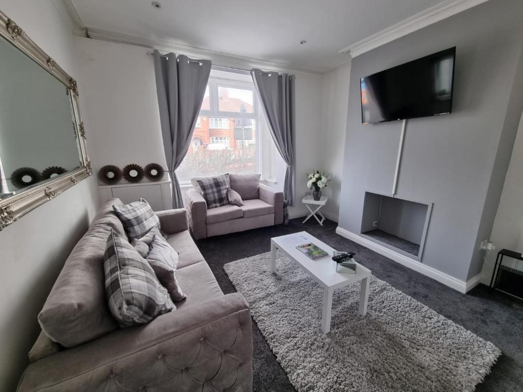 uma sala de estar com um sofá e uma televisão em 264 The Hungerford em Crewe