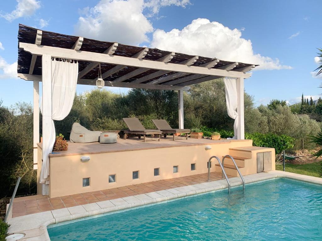 a swimming pool with a pergola and a swimming pool at Kleine Finca mit privatem Pool und Klima, ruhige Lage in Algaida