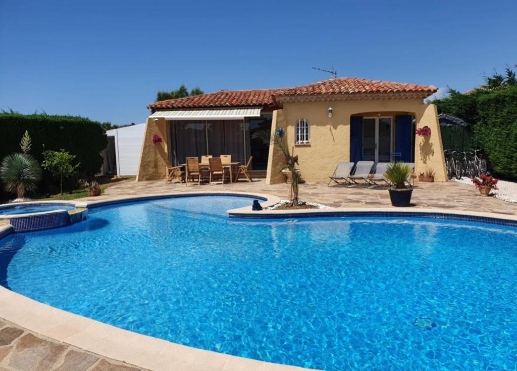een groot blauw zwembad voor een huis bij Villa au calme avec piscine privative in Bormes-les-Mimosas
