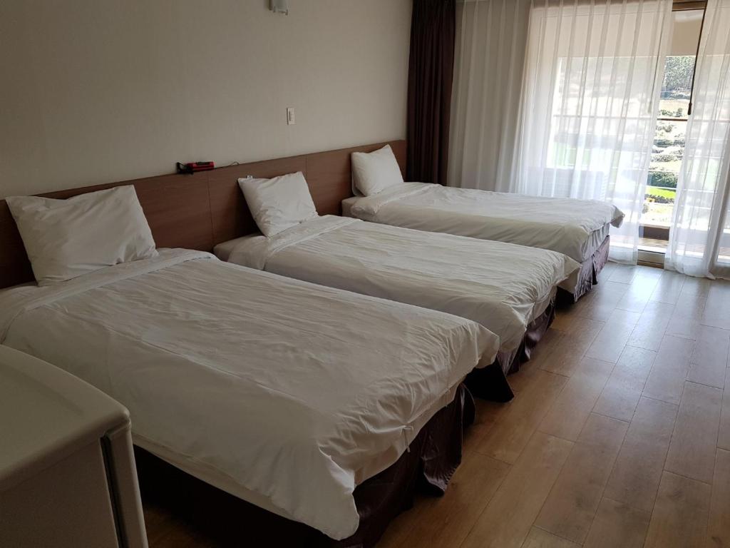 Postel nebo postele na pokoji v ubytování Hi Jeju Hotel