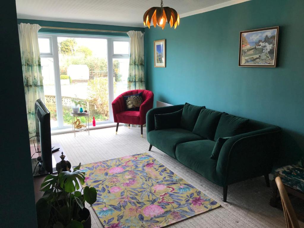 a living room with a green couch and a blue wall at LetAway - Tom's Cabin, Staithes in Staithes