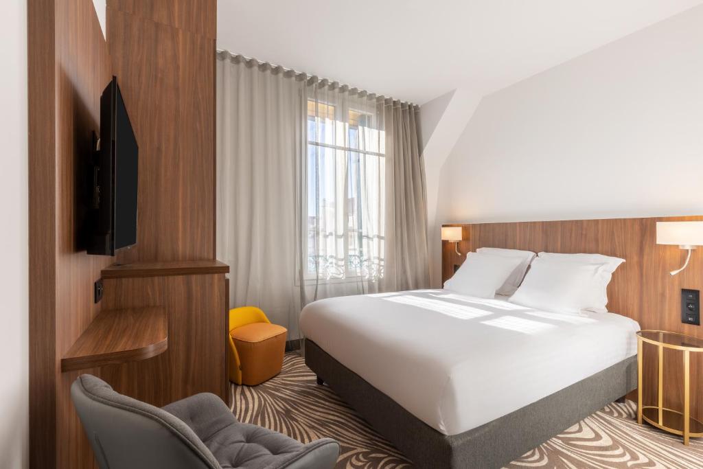 a hotel room with a bed and a chair at Hôtel Apollinaire Nice in Nice