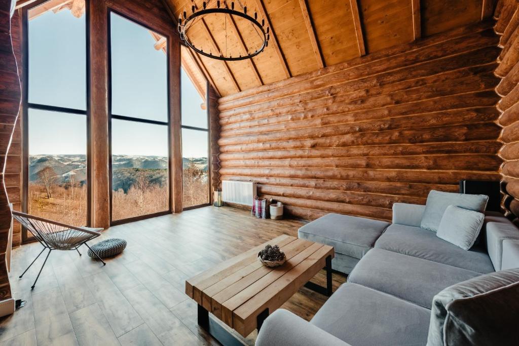 a living room with a couch and a table at Poeme Chalet in Râșca