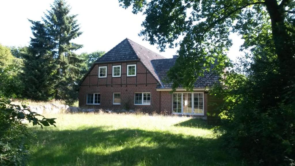 una casa de ladrillo rojo con techo de gambrel en Heidehof Jungemann en Bispingen