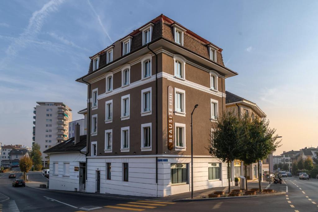 un bâtiment marron et blanc au coin d'une rue dans l'établissement Beausite, à Lausanne