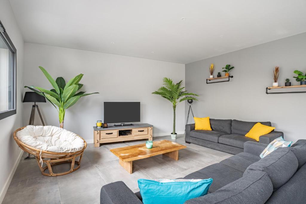 a living room with a couch and a tv at L&#39;Attrape Rêves in Villelongue-dels-Monts