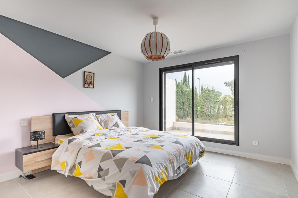 a bedroom with a bed and a large window at L&#39;Attrape Rêves in Villelongue-dels-Monts