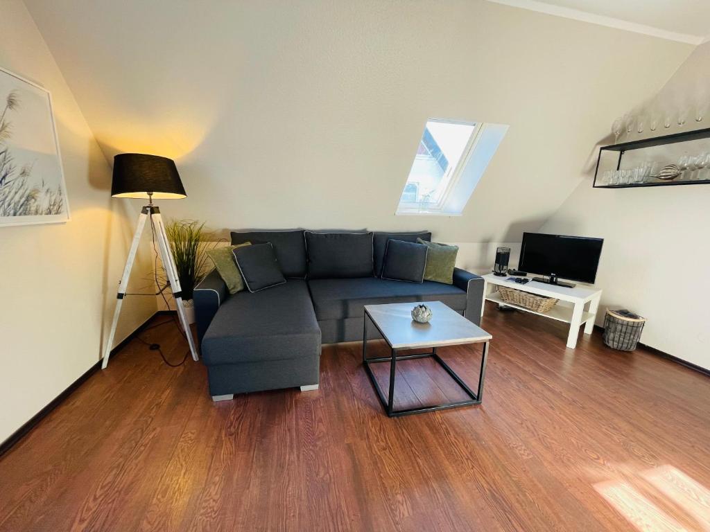 a living room with a couch and a table at Exclusives Apartment im Herzen von Westerland in Westerland (Sylt)