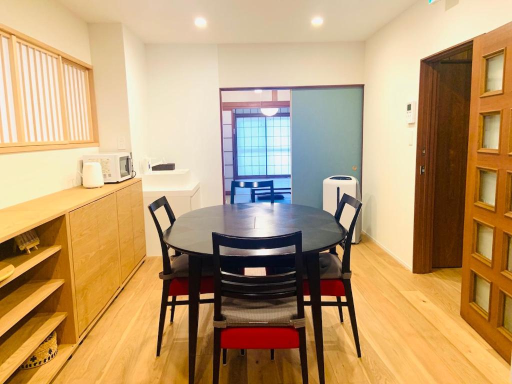 una cucina e una sala da pranzo con tavolo e sedie di Yokohama HY House a Yokohama