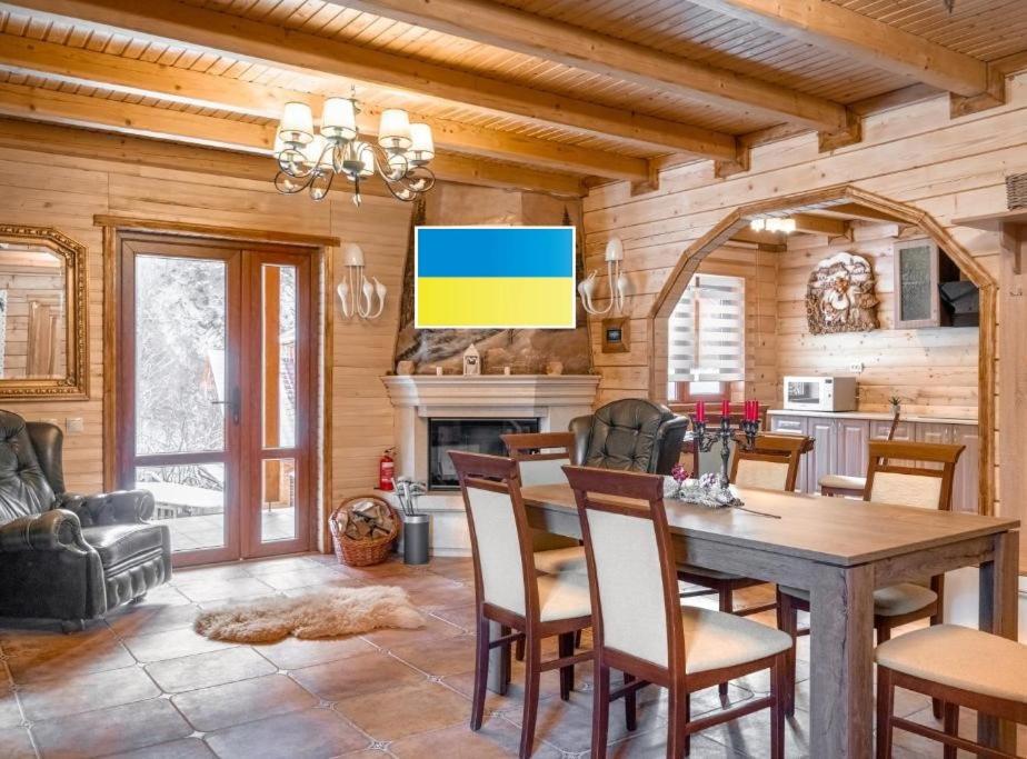 eine Küche und ein Esszimmer mit einem Tisch und Stühlen in der Unterkunft Villa Ladna Tatariv Bukovel in Tatariw