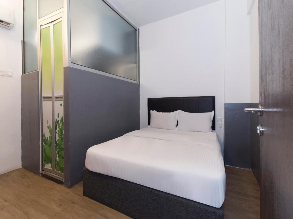a bedroom with a white bed and a door at Intime Hotel Kuchai Lama Kuala Lumpur in Kuala Lumpur