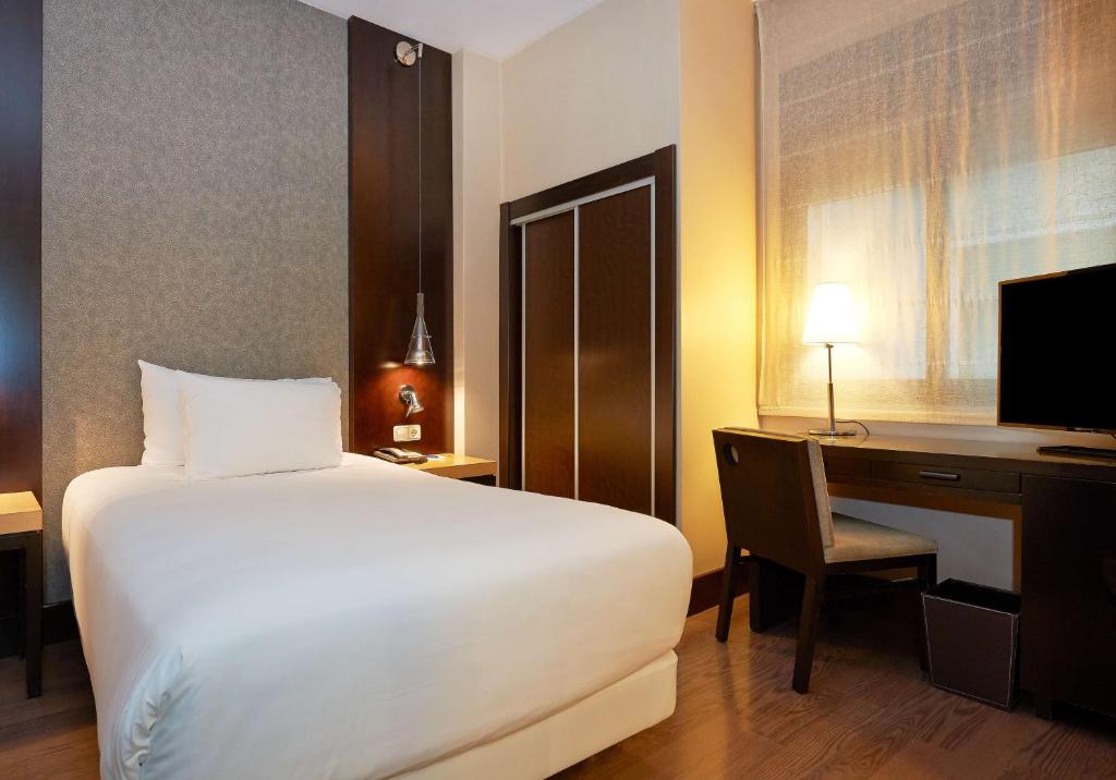 Cama ou camas em um quarto em NH Barcelona Eixample