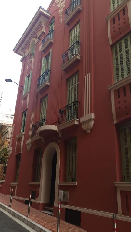 蒙特卡罗Quiet flat center Monaco的一座红色的建筑,旁边设有阳台