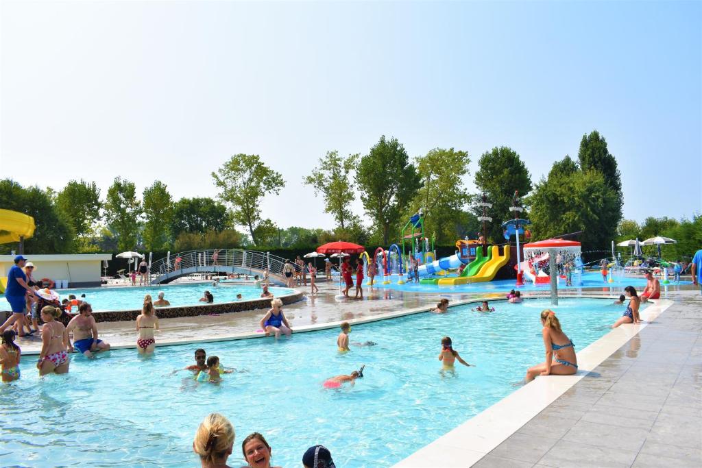 un grupo de personas en una piscina en un parque acuático en Adria Holiday Villaggio San Francesco en Duna Verde