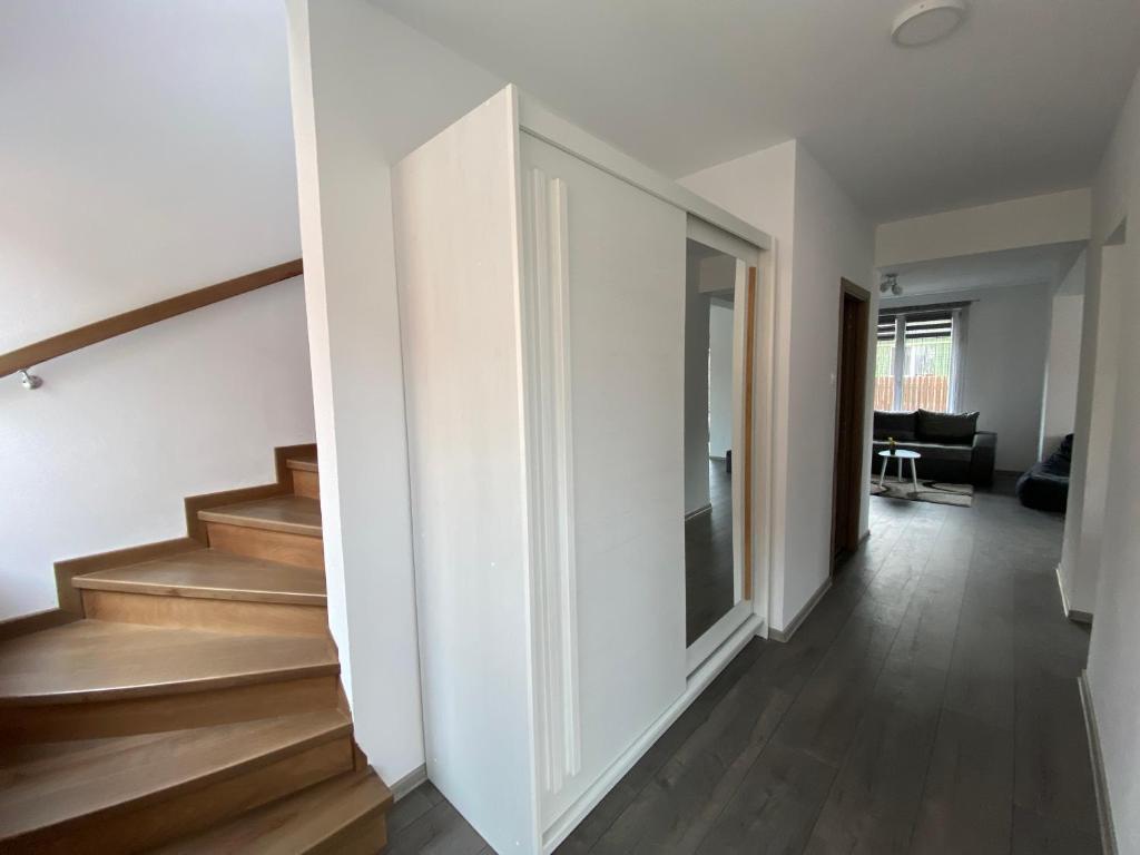 a hallway of a house with wooden floors and stairs at FENYŐ APARTMAN House I in Odorheiu Secuiesc