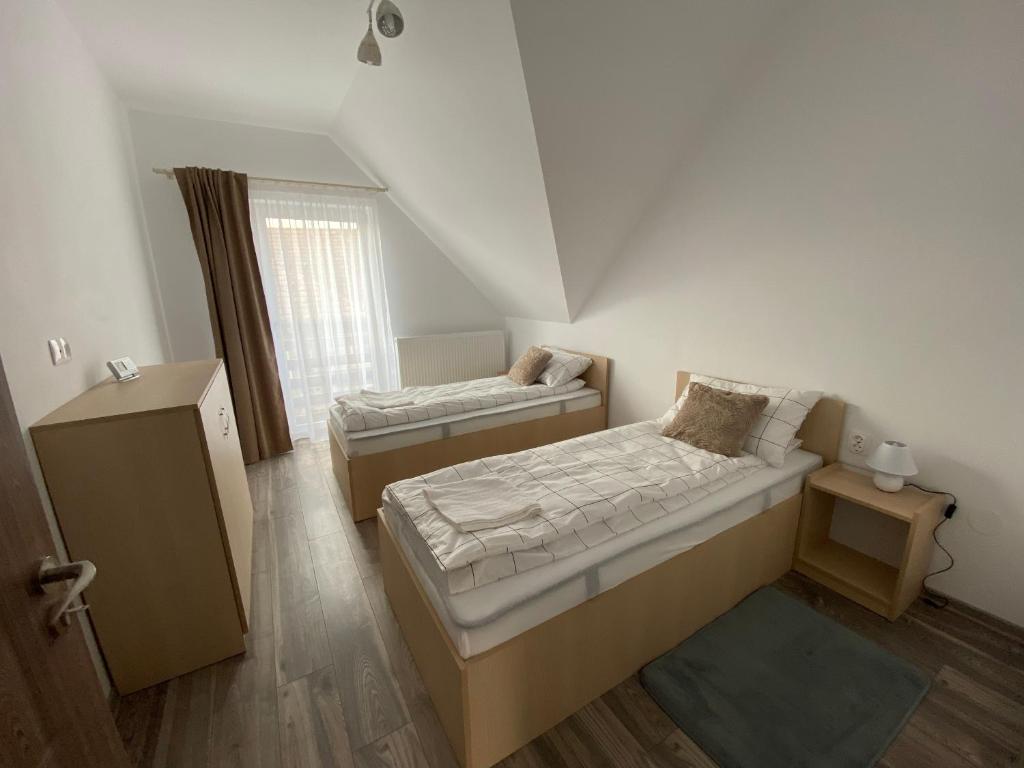 a small room with two beds and a window at FENYŐ APARTMAN House I in Odorheiu Secuiesc