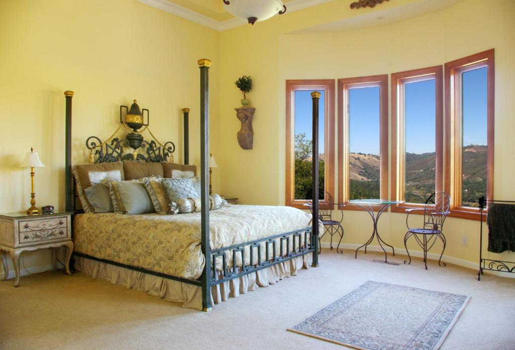 ein Schlafzimmer mit einem Bett und einigen Fenstern in der Unterkunft Bella Vista Bed and Breakfast in Coloma