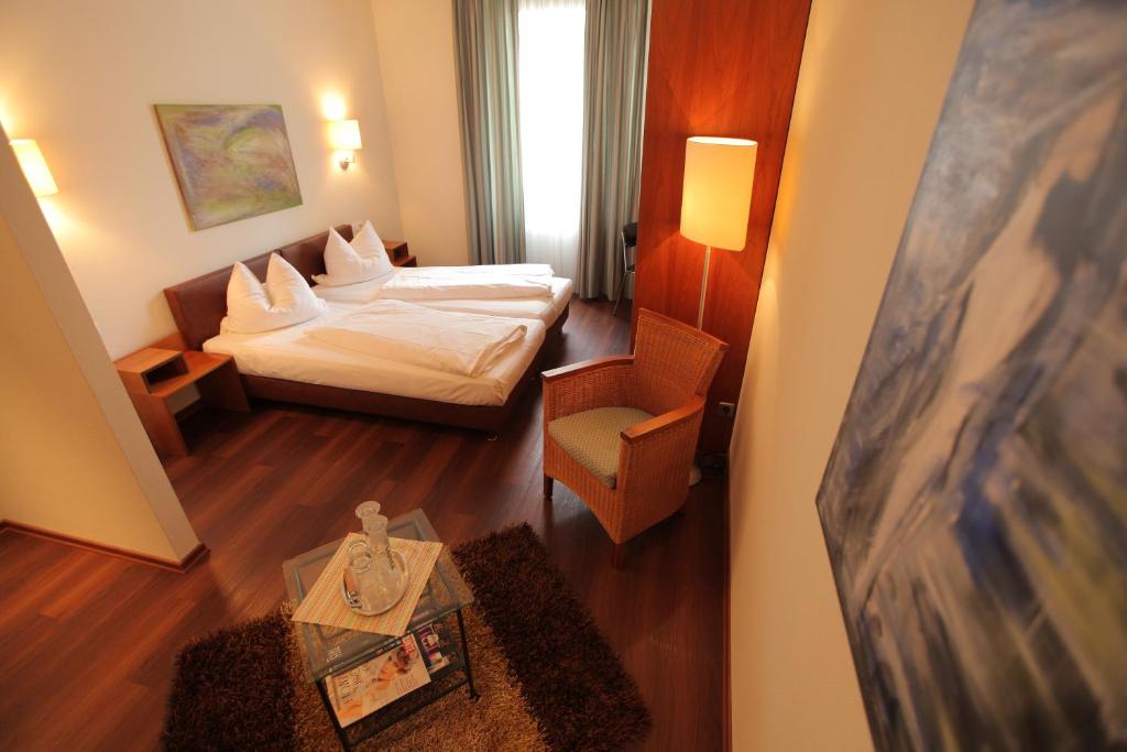 Piccola camera d'albergo con letto e tavolo di Hotel MARIOTTO am Burghof a Lörrach