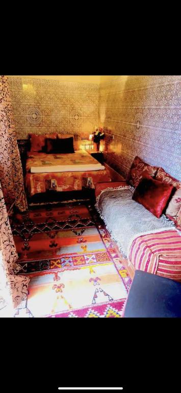 a bedroom with two beds and a rug at Dar Lalla Aicha in Rabat