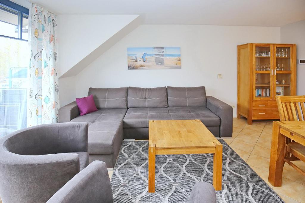 uma sala de estar com um sofá e uma mesa em Feriendorf Papillon Wohnung 05-5 em Boltenhagen