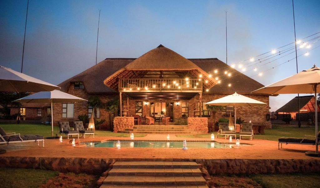 una casa con piscina frente a ella en Morakane Safari Lodge, en Vryburg