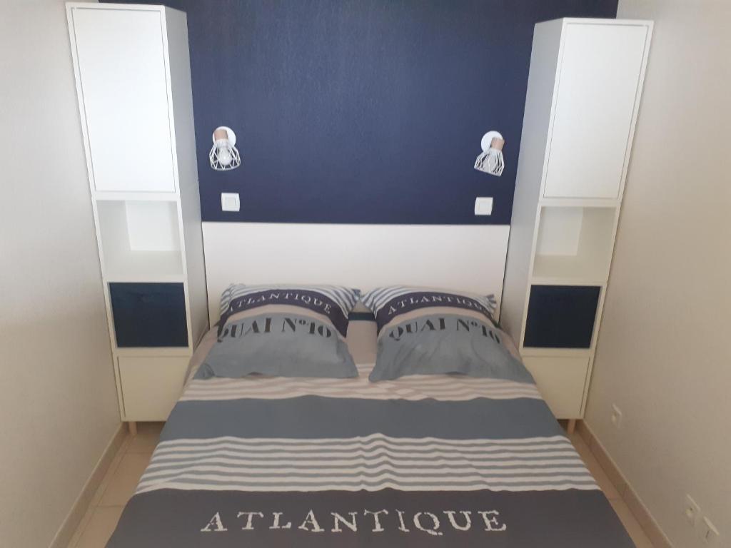 a small bed with two pillows in a room at APPARTEMENT VUE OCEAN ET PISCINE in Lacanau