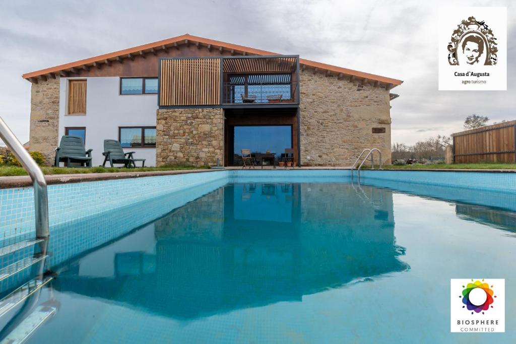 uma casa com piscina em frente a um edifício em Casa D'Augusta - Agroturismo em Miranda do Douro