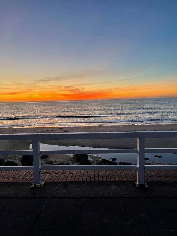 a bench on the beach with the sunset in the background at Strandapartment in Westerland für 2-4 Personen in Westerland