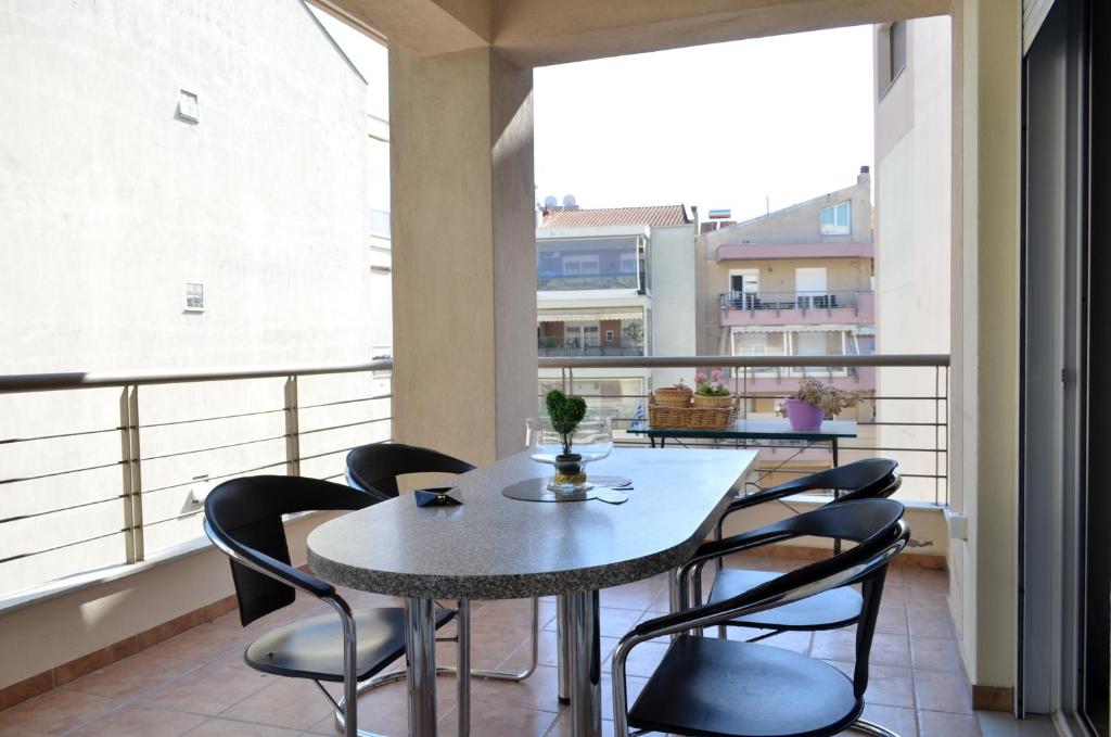 jadalnia ze stołem i krzesłami na balkonie w obiekcie Delmare Dion apartment w Salonikach