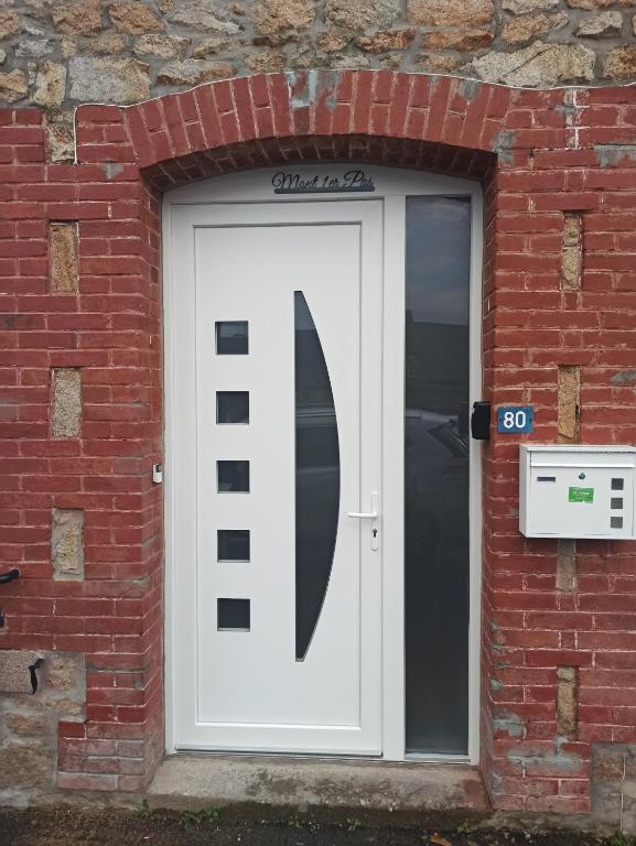 a white door with a sign on it in a brick building at &quot;Mont 1er Pas&quot; proche Mont St Michel in Pontorson