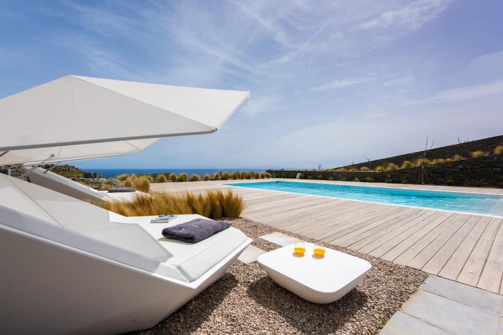 a white boat sitting next to a swimming pool at Elements Sifnos Boutique in Faros