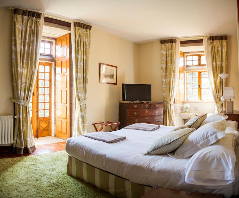 1 dormitorio con 1 cama grande y TV en Pazo da Touza, en Nigrán