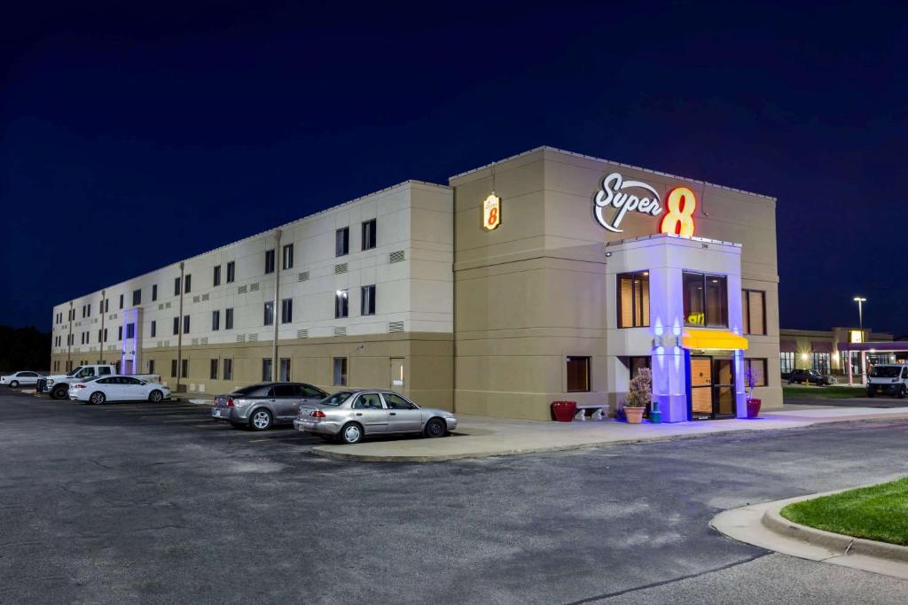 a hotel with cars parked in a parking lot at Super 8 by Wyndham Wichita North in Wichita