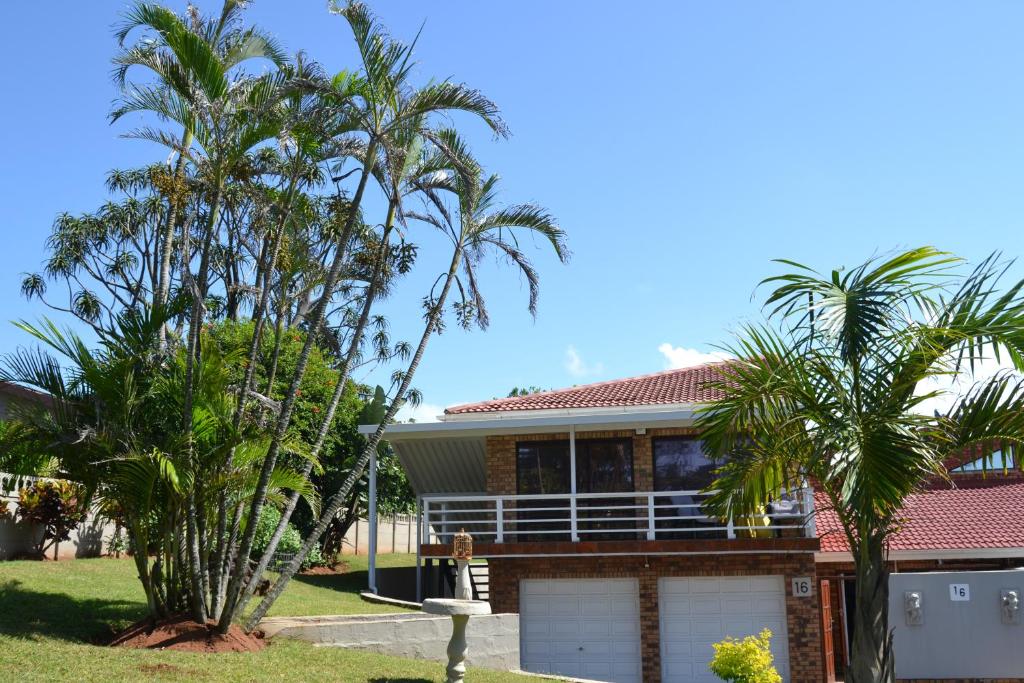 a house with two palm trees in front of it at Palmtree place - Stylish self catering unit in Umkomaas