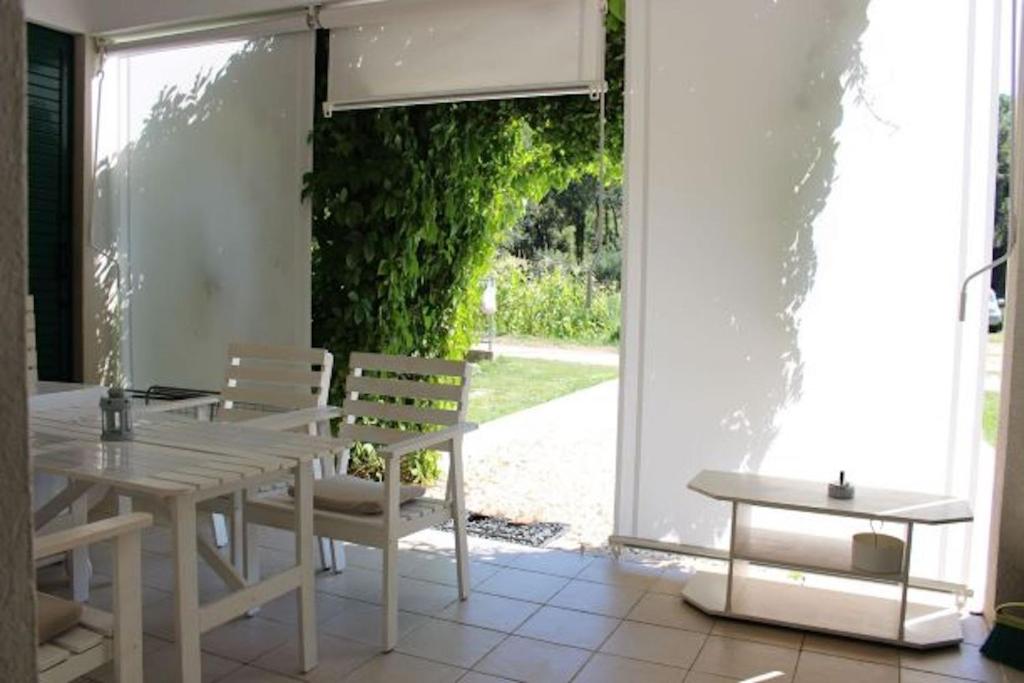 逐雅納的住宿－Apartment Jon Zuljana，绿色植物庭院里的白色桌椅