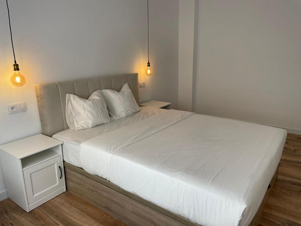 een bed met witte lakens en kussens in een slaapkamer bij Apartamento Dakota in Sant Carles de la Ràpita