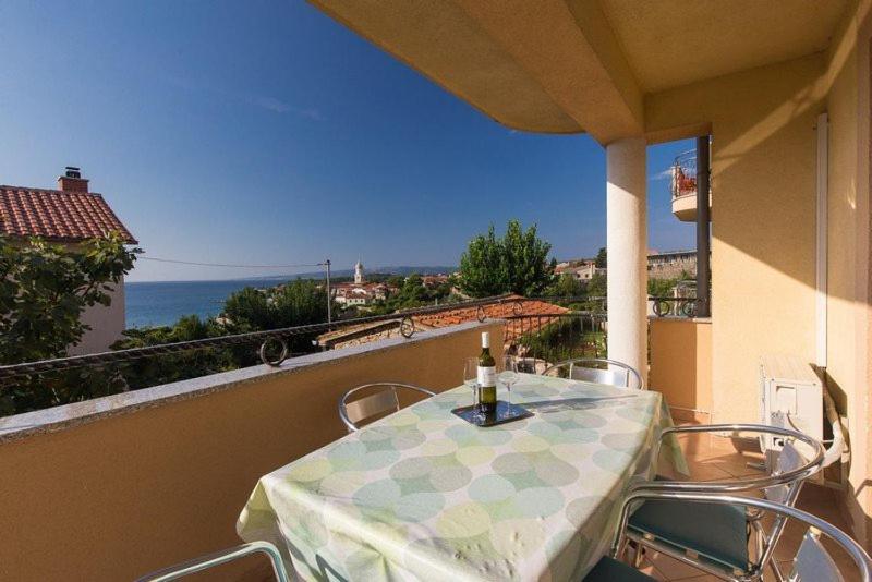 einen Tisch und Stühle auf einem Balkon mit Meerblick in der Unterkunft Marija F4 Apartment in Krk