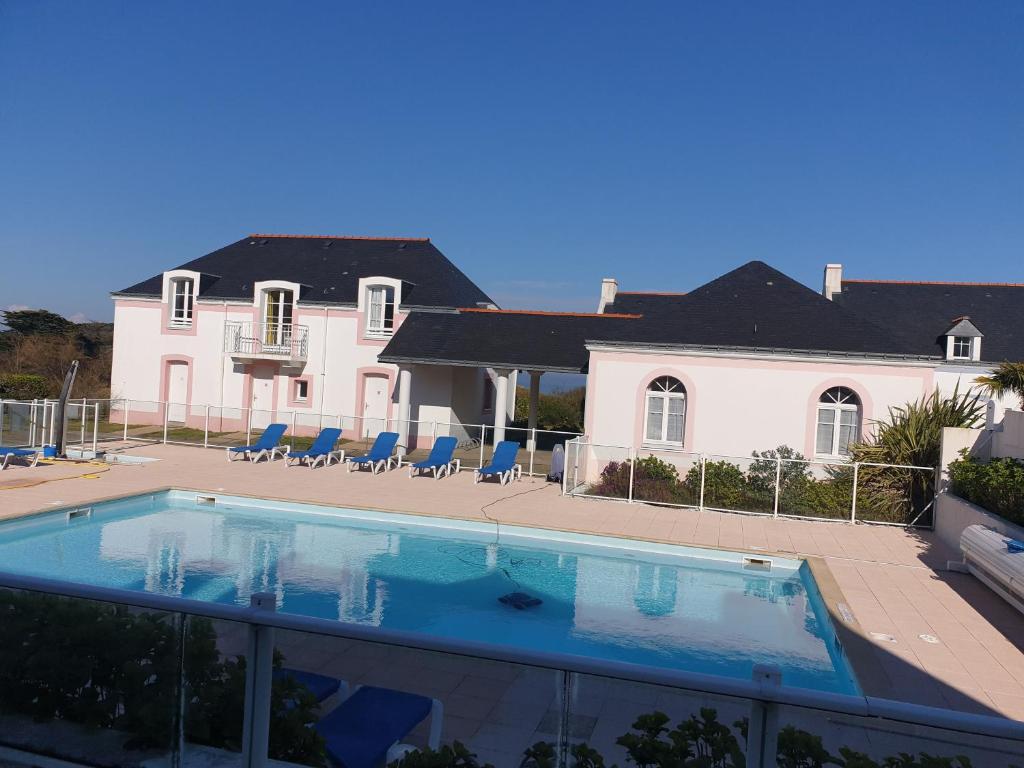 une grande piscine en face d'une maison dans l'établissement Location LOC'MARIA - Résidence Marie-Galante - Location Professionnelle, à Locmaria