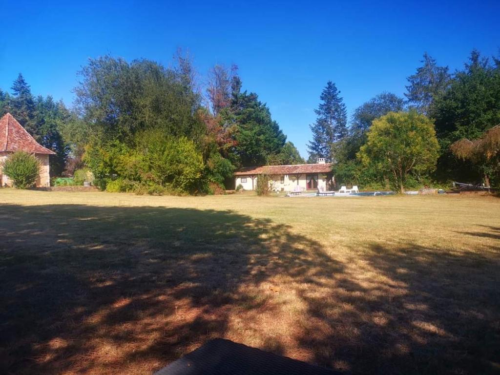 een groot grasveld met een huis op de achtergrond bij Printemps Quatre Saisons in Bergerac