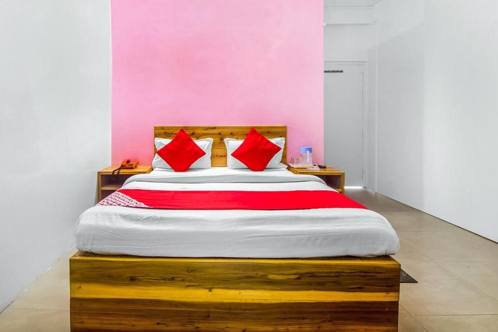 a bedroom with a large bed with red pillows at Shillong Guest House in Shillong