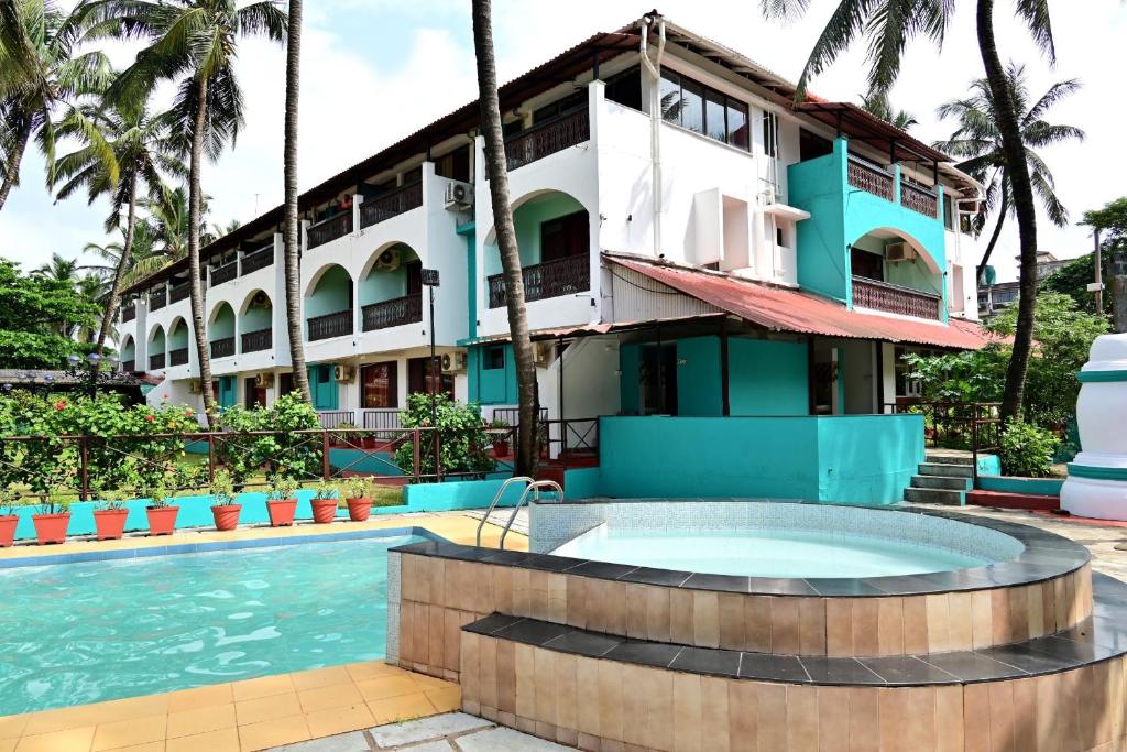un hotel con piscina frente a un edificio en Swim Sea Beach Resort, Panjim, en Taleigao