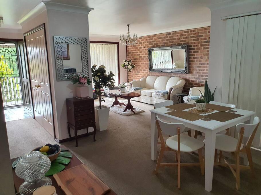 a living room with a white table and a couch at The Junction Estate COOL CALM COZY A Home N Host Property in Wallerawang