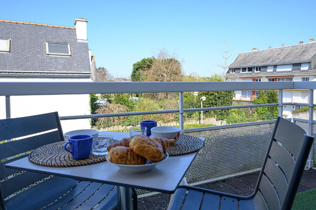 a table with a plate of food on a balcony at LE MATISSE - 39m2 dans Vannes avec parking privé in Vannes