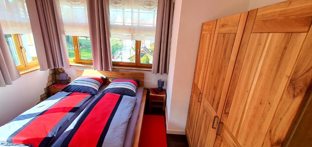 1 dormitorio con 2 camas y armario de madera en Sonniges Eck Ferienwohnung 2 en Rathen